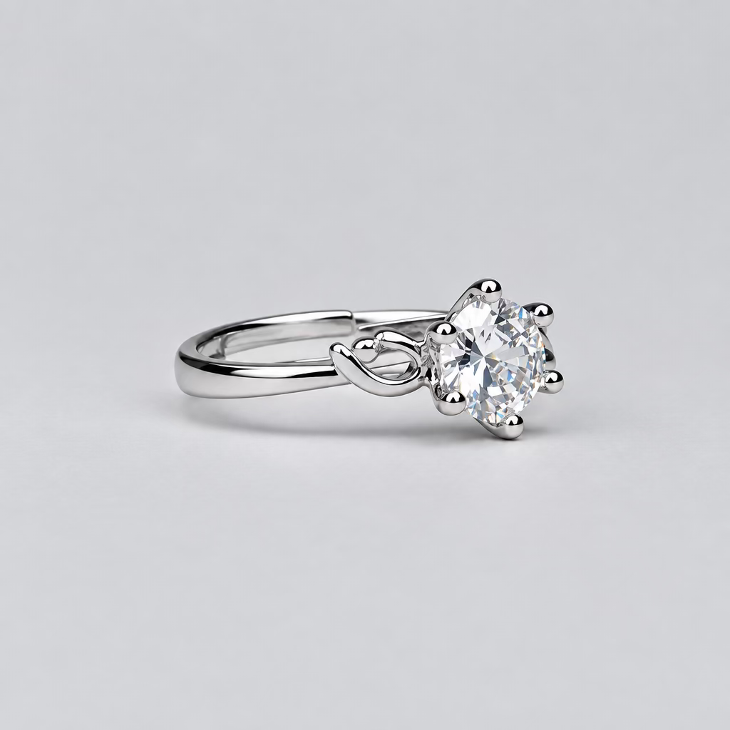 A silver ring with a clear gemstone is displayed in the foreground on a light surface, with a white jewelry box branded 'Meenu' in the blurred background.