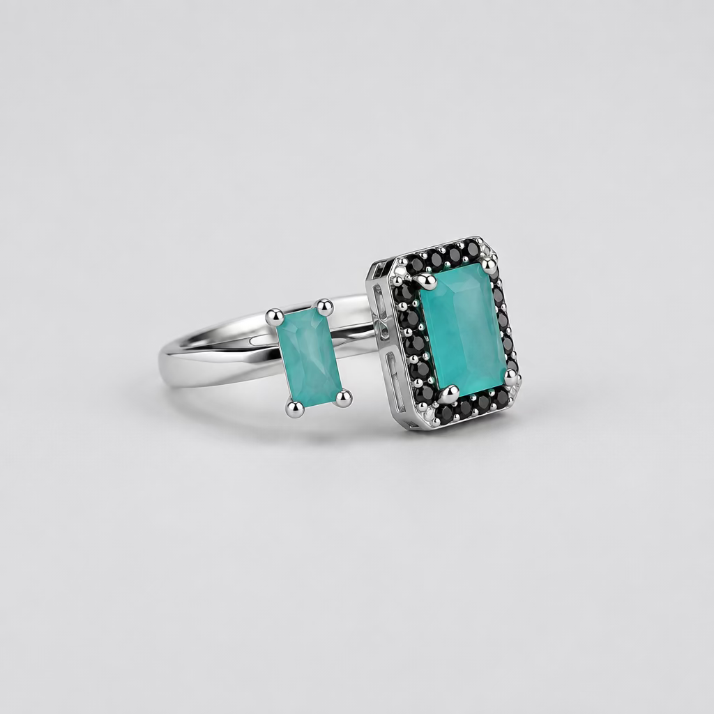 A silver ring with a rectangular turquoise stone and small side stones, displayed in front of its white Meenu.pk branded jewelry box on a light surface against a dark background.