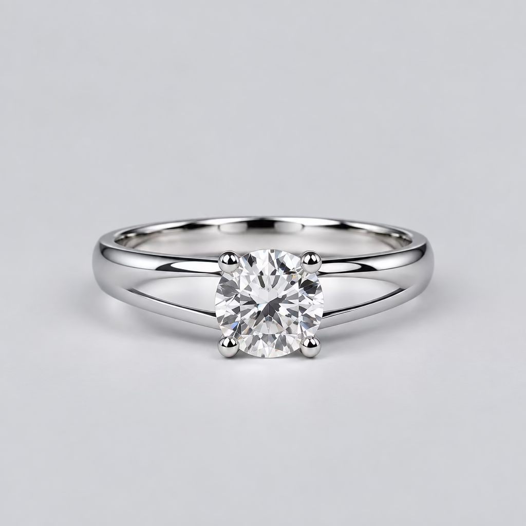 A silver ring with a clear central gemstone is displayed on a light surface, with a white Meenu jewelry box in the blurred background.