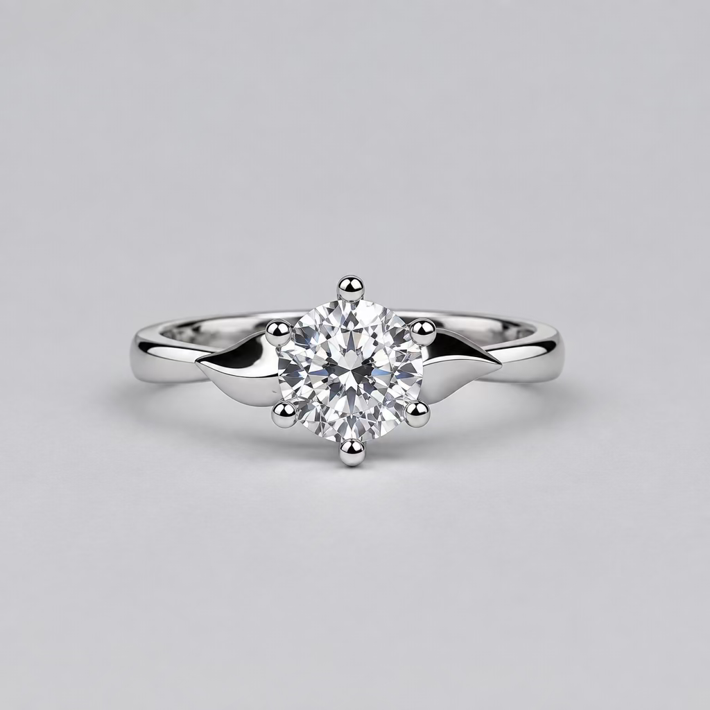 A silver engagement ring with a clear round-cut center stone is displayed on a light surface, with a white Meenu jewelry box in the blurred background.