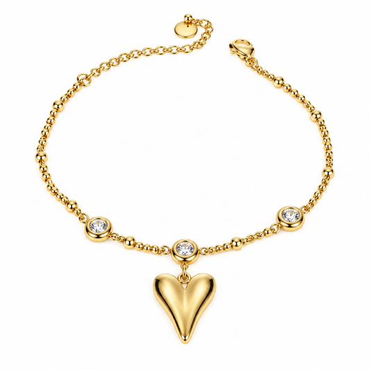 A delicate gold chain bracelet featuring a central black heart pendant and small metallic bead accents, displayed on a plain white surface.